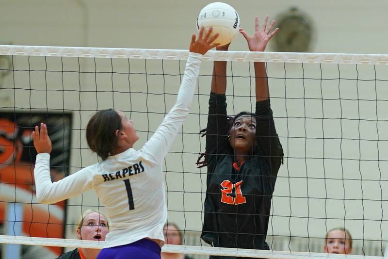 Sandwich’s Alayla Harris (21) defends the net against a kill attempt by Plano’s Hennessy Pena (1) during a volleyball match at Sandwich High School on Tuesday, Sep 10, 2024.