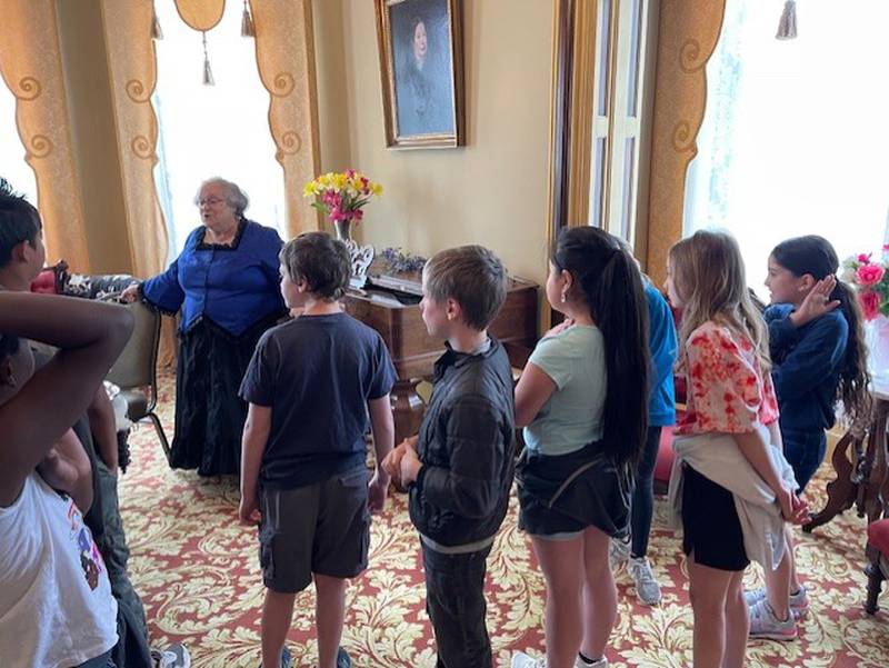 Lorraine McCallister, president of the Reddick Mansion Association, stops in the formal parlor of the Reddick Mansion while giving a tour to Jefferson School fourth graders. The students were just a sampling of the 898 people who have toured the mansion since January.