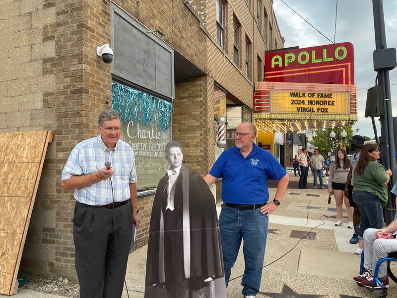 Jim Dunn (left), chairman of the board for the Bureau County History Center, and Lex Poppens (right) executive director, listen to a composition by Princeton native Virgil Fox, depicted in the large cutout, during the unveiling of Fox's' star on Thursday, Sept. 5, 2024. Fox was an internationally acclaimed musician who earned a star in downtown Princeton.