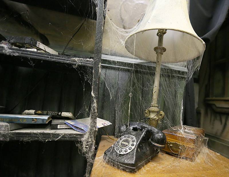 Fake cobwebs cover a dial telephone and table lamp at the Insanity Haunted House inside the Peru Mall on Thursday, Oct. 6, 2022.