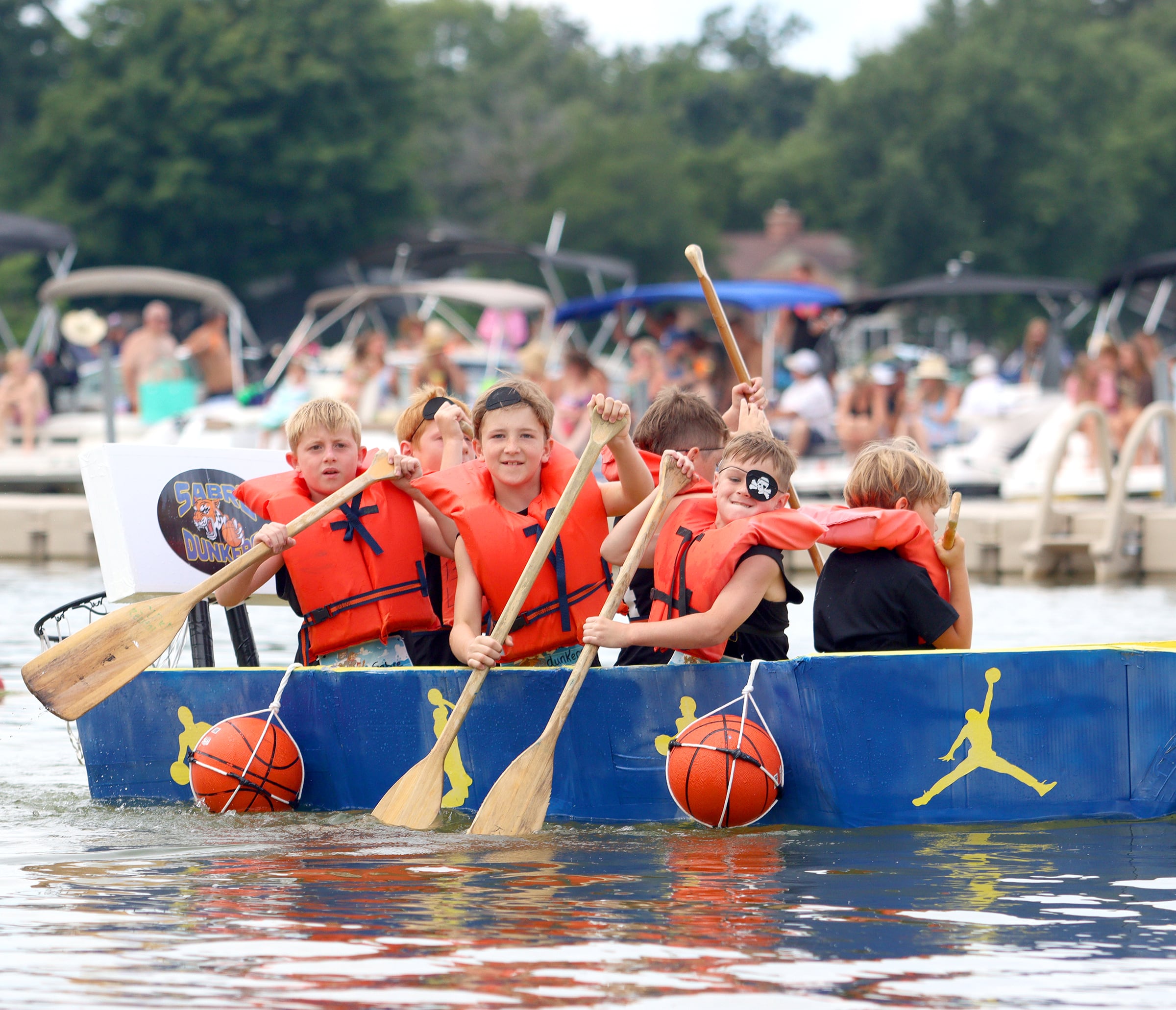 The team Sabre Dunkers powers through the Cardboard Regatta on Crystal Lake Saturday.