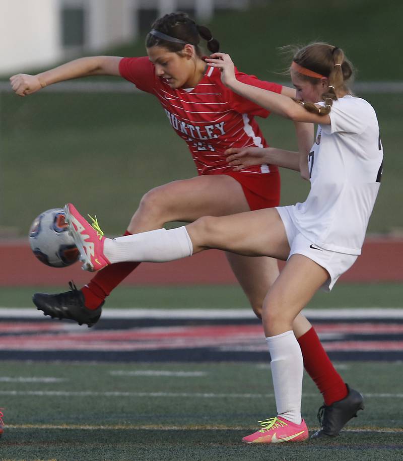 McHenry's Addie Michelau kicks the ball away form Huntley’s Ali Hornberg during a Fox Valley Conference soccer match Thursday, April 13, 2023, at Huntley High School.