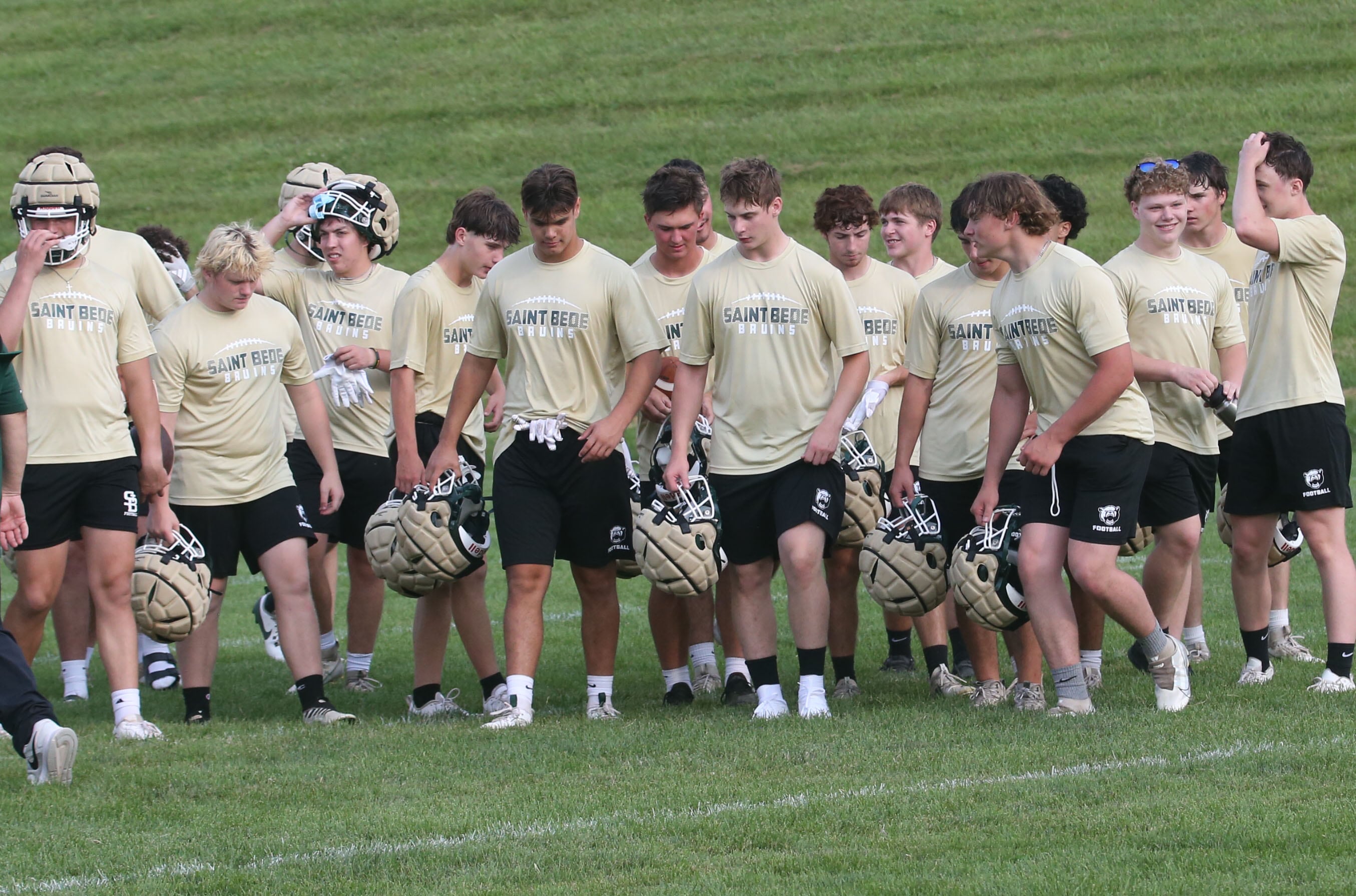 Members of the St. Bede football team walk off of the field after a 7-on-7 scrimmage with Ottawa in mid-July at Ottawa High School.