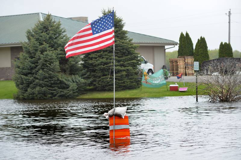 The Mississippi River flooded streets just west of Main Street in downtown Savanna. Here, someone placed an American flag on one of the barricade barrels.
