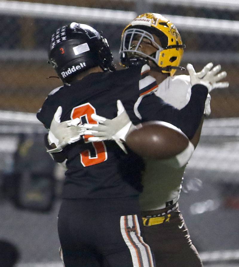 Jacobs' Prince Barnes tries to catch the football as he is hit by McHenry's Rogelio Rios during a Fox Valley Conference football game on Friday, Oct. 18, 2024, at McKracken Field in McHenry.