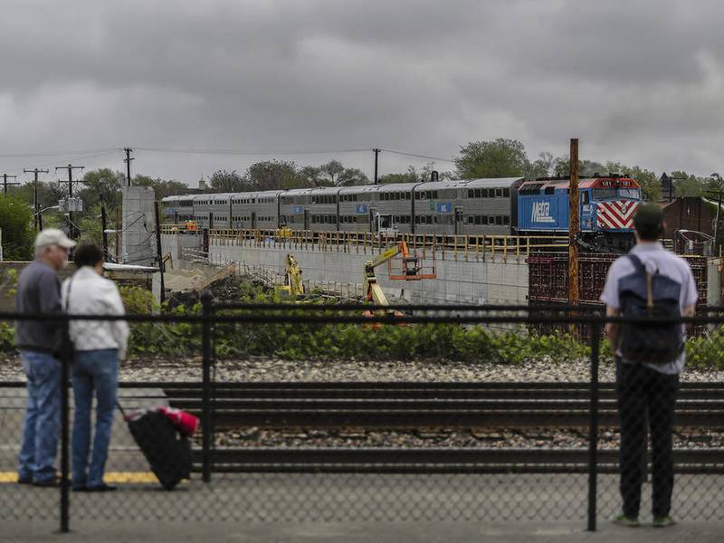 Construction of the Joliet Transportation Center is seen in May 2014 as a Metra train moves along the Rock Island District track near Joliet's Union Station. The project is in trouble, running over budget and facing demands from the state that Joliet come up with nearly $5 million needed to finish the job.