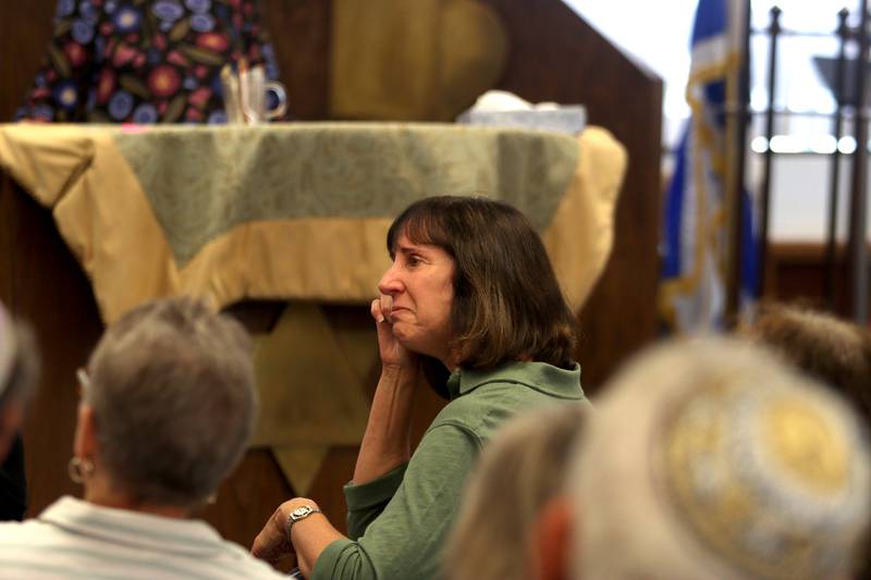 Paula Eskoz of Lakewood, a 27-year congregation member, wipes away tears while members share memories as the McHenry County Jewish Congregation held a deconsecration ceremony at their Ridgefield Road location in preparation for a move to the Tree of Life Unitarian Church in McHenry on Sunday, August 18. Mezuzot were removed from doorways and the Torah Scrolls were removed from their ark and transported  to the new building as worshipers consecrated the new building as their synagogue.