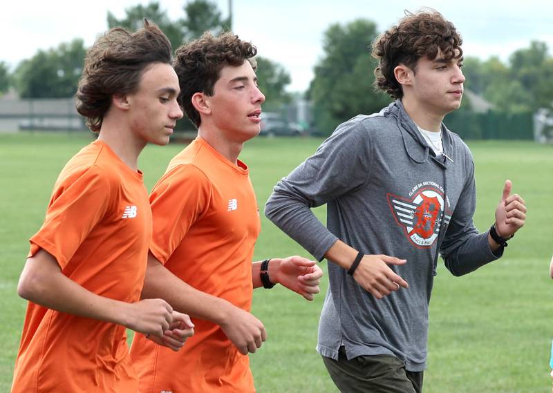 Jacob Barraza (right) warms up with his teammates during practice Monday, Aug. 14, 2023, at DeKalb High School.