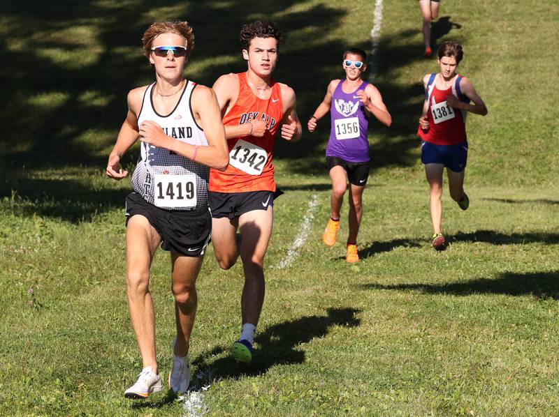 Kaneland’s Evan Nosek (left) and DeKalb’s  Jacob Barraza (second from left) make their way down a hill Tuesday, Sept. 3, 2024, during the Sycamore Cross Country Invite at Kishwaukee College in Malta.