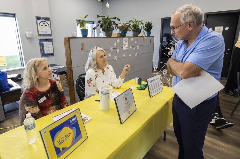 NAMI Sauk Area representative Melissa Thake (left) and Cheryl Robinson, co-president, speak with Jeff Neubauer Friday, April 12, 2024, during an open house in Sterling.