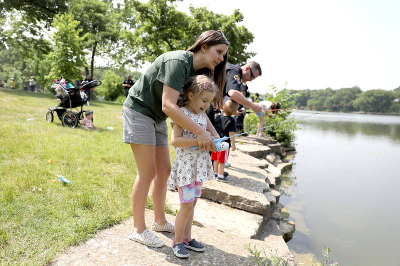 Caitlin Maurer fishes with her daughter, Annabelle, 4, during the Wheaton Police Department and DuPage County Forest Preserve Police Cops & Bobbers community fishing event at Herrick Lake Forest Preserve in Wheaton on Wednesday, June 7, 2023.