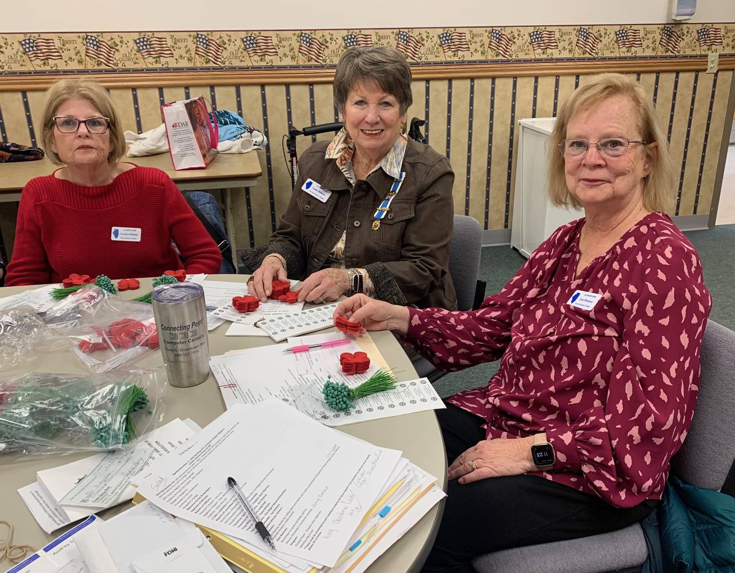 Fort du Rocher Chapter of the Daughters of the American Revolution members Carolyn Schultz, Leslie Althaus and Joni Bratney work on the poppy project.