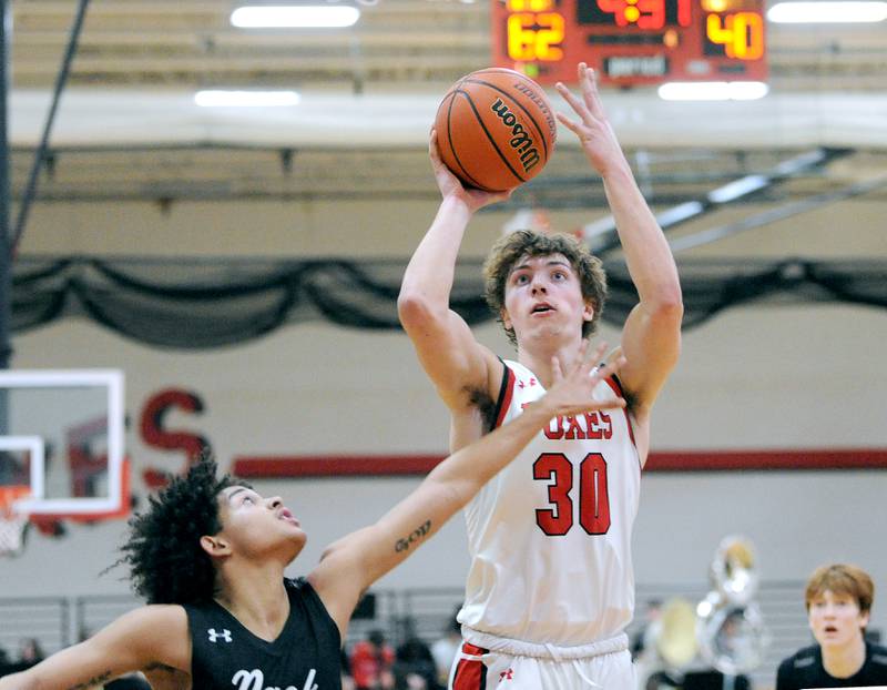 Yorkville's Bryce Salek (30) takes a shot over Oswego East defender Drey Wisdom during a varsity basketball game at Yorkville High School on Friday, Feb. 9, 2024.