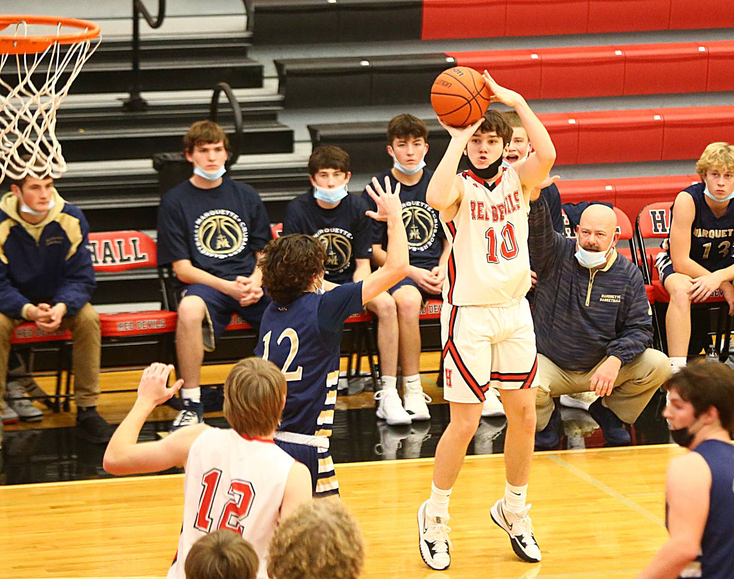 Hall's Ethan Plym, (10) shoots a three-point basket over Marquette's Nathan Kuykendall, (12) during the 47th Colmone Classic tournament on Tuesday Dec. 7, 2021 at Hall High School in Spring Valley.