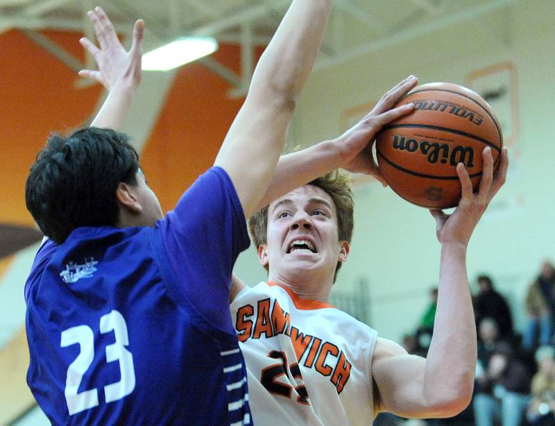 Sandwich's Dom Rome (22) makes a tough shot against Plano defender Isaiah Martinez (23) during a varsity basketball game at Sandwich High School on Tuesday, Feb. 13, 2024.