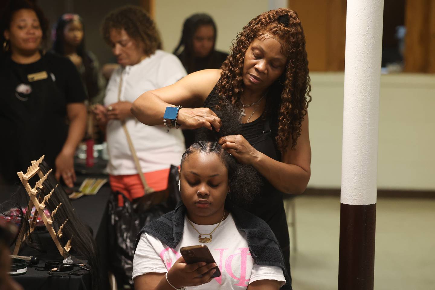 Taniya Taylor gets her hair braided by Deanna Simpkins at the Healing the Hood event held at the St. Mark CME Church in Joliet on Saturday June 29, 2024.