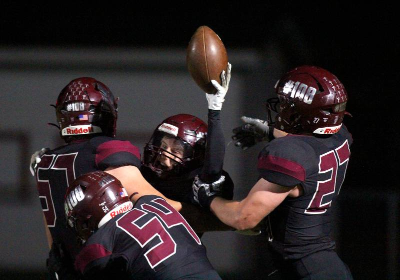 Marengo’s Alten Bergbreiter is mobbed in the end zone with a touchdown against Richmond Burton in varsity football at Rod Poppe Field on the campus of Marengo High School in Marengo on Friday, Oct. 18, 2024.