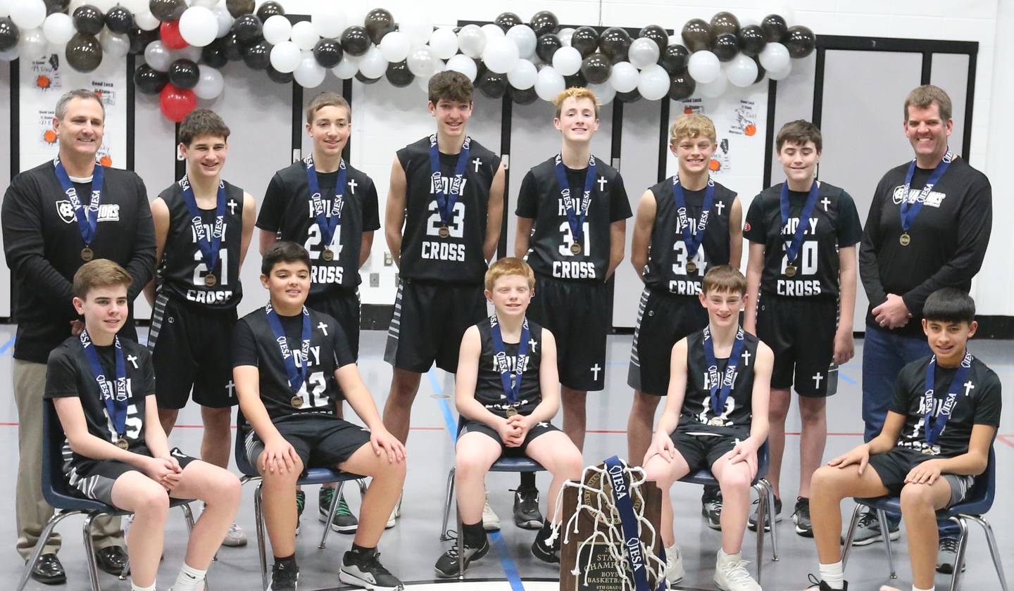 Members of the Mendota Holy Cross eighth-grade boys basketball team pose with the Class 1A State chamipionship trophy during a reception on Tuesday, Feb. 20, 2024 at Holy Cross School. The team beat Pana Sacred Heart 41-33 to win the IESA Class 1A State championship.