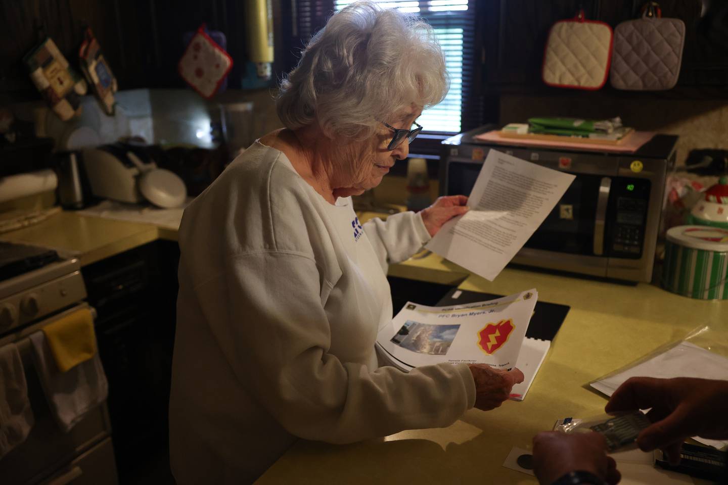 Barbara Lee Cerney looks over the Amry’s indentification briefing documents of her brother PFC Bryan Myers Jr. at her home in Shorewood on Friday, May 24, 2024. PFC Bryan Myers Jr.’s remains were recently returned to family after being kill in Korea in 1950.
