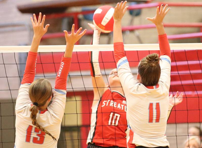 Streator's Shaelyn Groesbeck hits the ball as Ottawa's Ayla Dorsey and Bell Markey look to block it on Thursday, Aug. 29, 2024 in Kingman Gym at Ottawa High School.