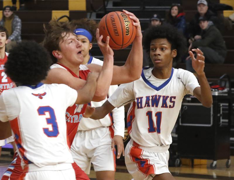 Marian Central's Christian Bentancur drives to the basket against Hoffman Estates’ Trendell Whiting (left)  and DJ Wallace during a Hinkle Holiday Classic basketball game Tuesday, Dec. 27, 2022, at Jacobs High School in Algonquin.