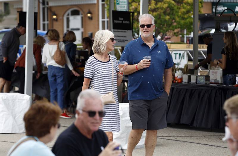 Kathryn and Bob Vann of Batavia sip wine as they stroll through the first day of the Festival of the Vine Friday, Sept. 6, 2024 in Geneva.