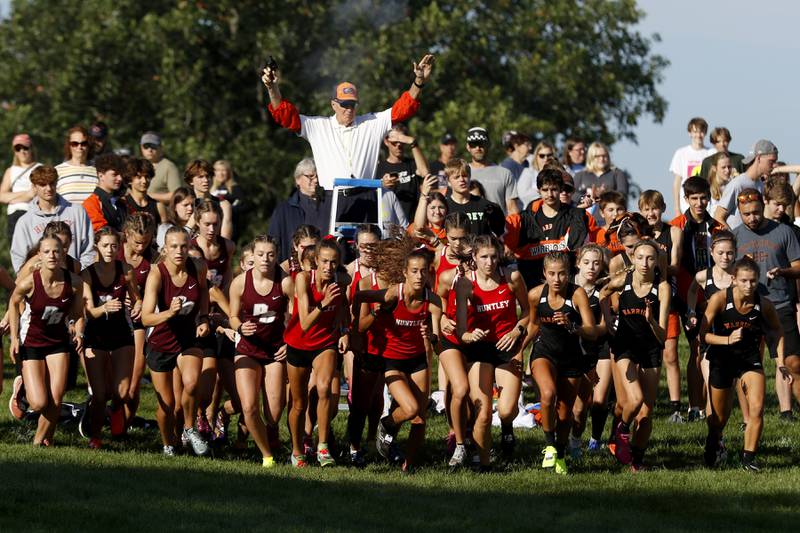 Runners fire off the starting line during the girls race of the McHenry County Cross Country Meet Saturday, August 27, 2022, at Emricson Park in Woodstock.