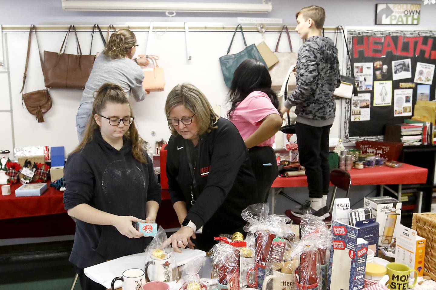Teacher Anne Whitney-Tubridy talks with student Edie Maihack on Tuesday, Dec. 5, 2023, as Edie and other students in the job skills class at Haber Oaks Campus School prepare to open their Christmas store at the school, which they run for fellow students to shop at using “Haber Bucks” money.