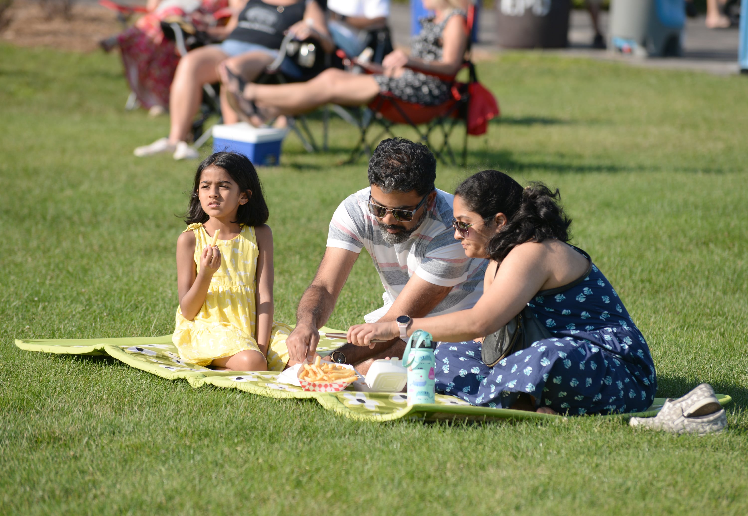Families including (left-right) Aavia Salil and Mukta Chitre of Elmhurst  enjoy a picnic while attending the Park Palooza at Berens Park Saturday Aug 19, 2023.