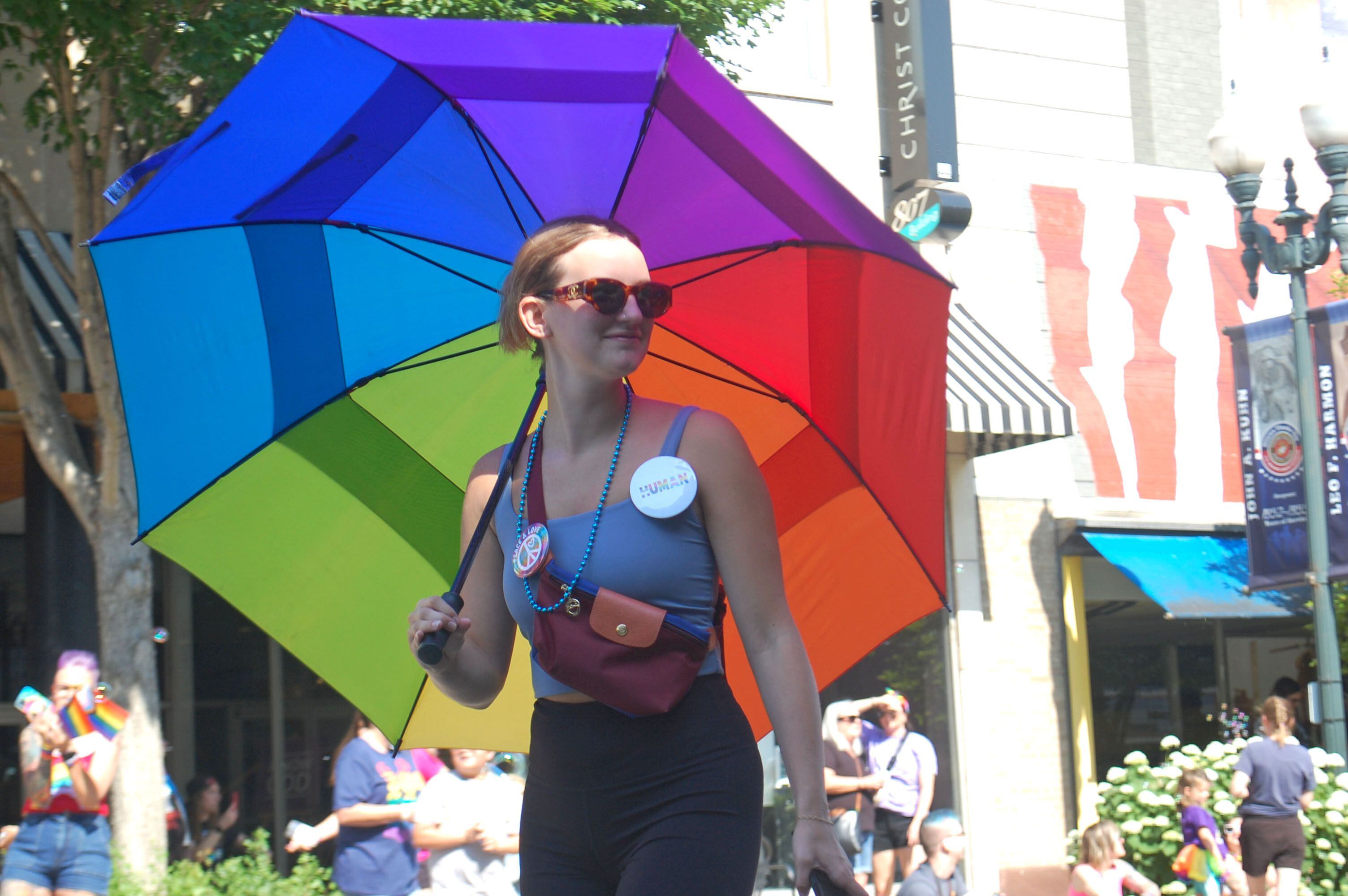 A marcher in the John Fisher Dann Memorial Pride Parade carries a rainbow-colored umbrella down La Salle Street in downtown Ottawa on Saturday, June 10, 2023.