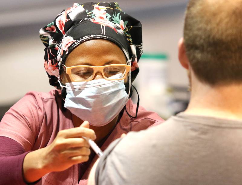 Lorri Cullen, a licensed practical nurse, administers the vaccine Wednesday to one of the many people who made appointments at the Convocation Center at Northern Illinois University in DeKalb.