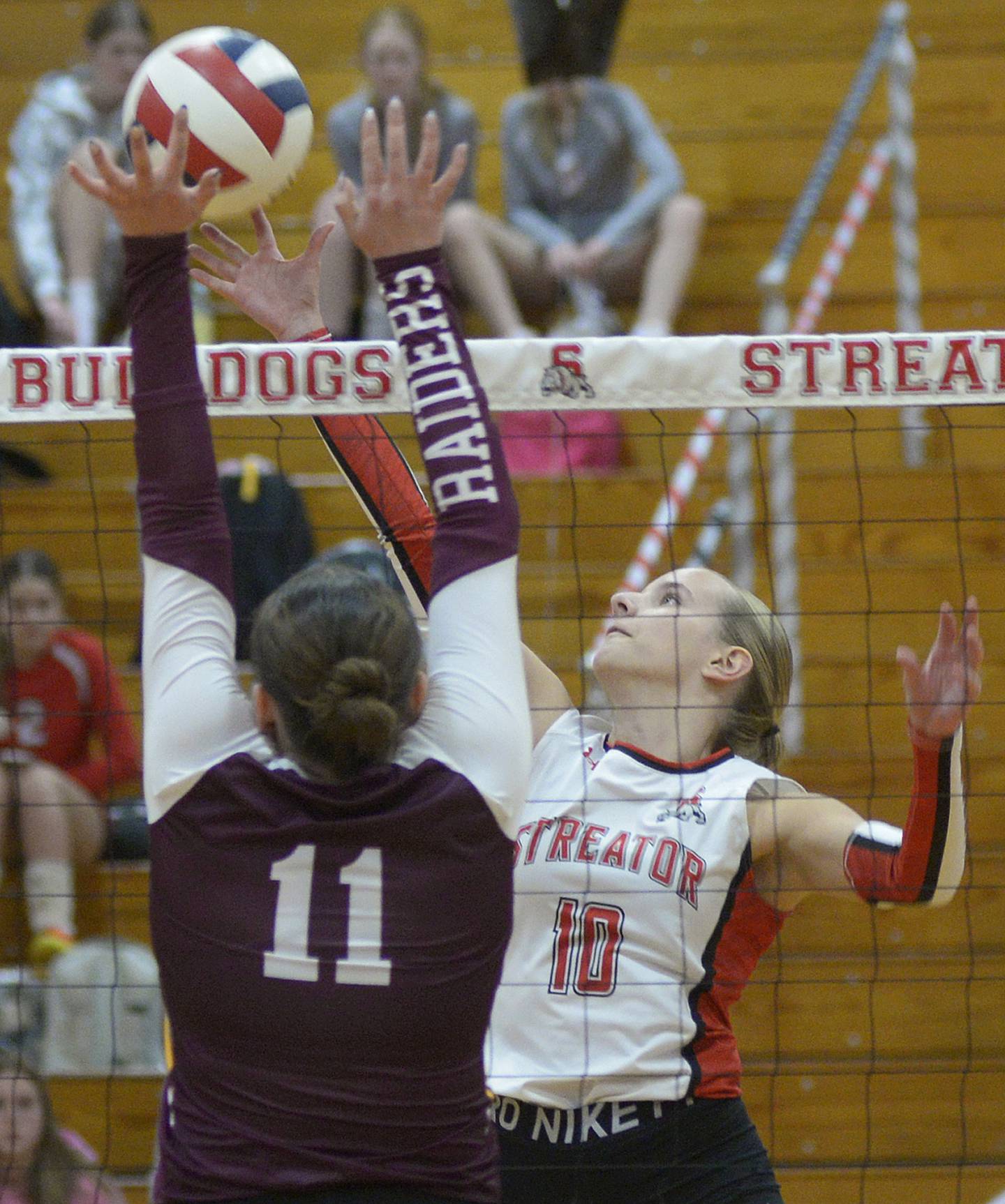 Streator senior Shaelyn Groesbeck works to get a tip past East Peoria’s Lizzie Stenger during the first set Monday at Streator.