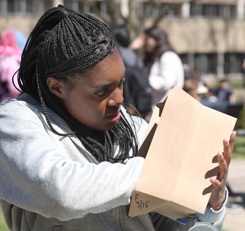 Amirah Elechi, a Northern Illinois University freshman from Chicago, builds an eclipse viewer Monday, April 8, 2024, at the NIU Solar Eclipse Viewing Party behind Davis Hall in DeKalb. Attendees were treated to perfect weather to watch the rare celestial event.