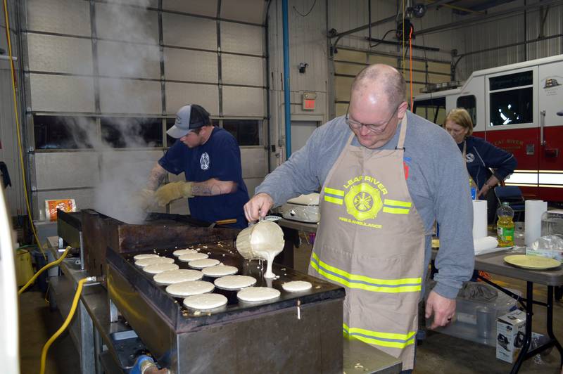 Leaf River Fire Protection District Deputy Chief Jeremy Glick makes another batch of pancakes on Feb. 25, 2023, during the annual Leaf River Firemen's Pancake Supper. Next to him, firefighter Austin Yuill cleans a grill in preparation for the next batch of sausage. A little over 700 people attended the fundraiser at the Leaf River fire station, raising $2,050.