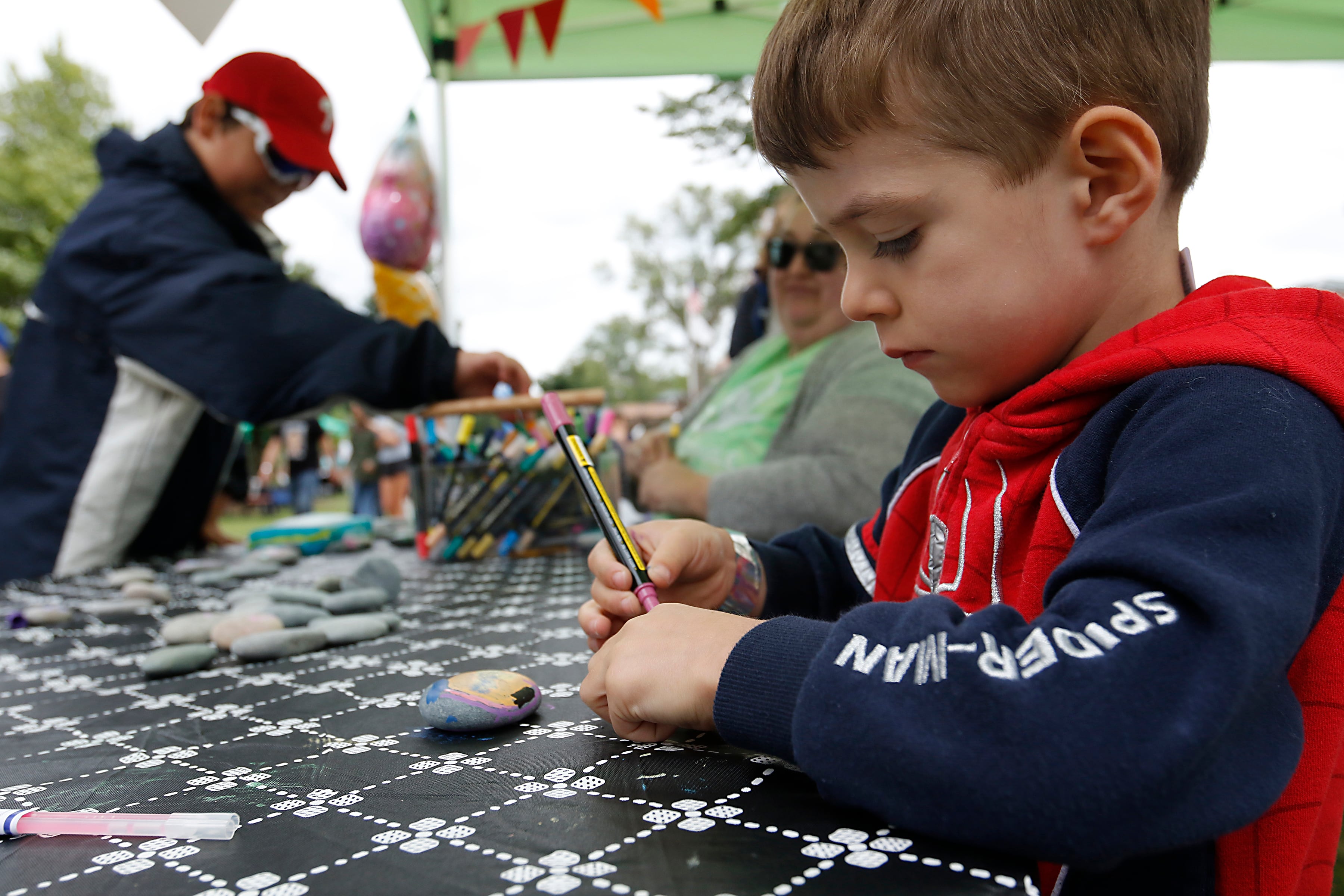 Henry Liddle, 4 paints a rock during the Ice Cream Fest on Friday, Aug. 9, 2024, at Crystal Lake’s Main Beach.  The second annual event featured music, ice cream venders and an ice cream eating contest.