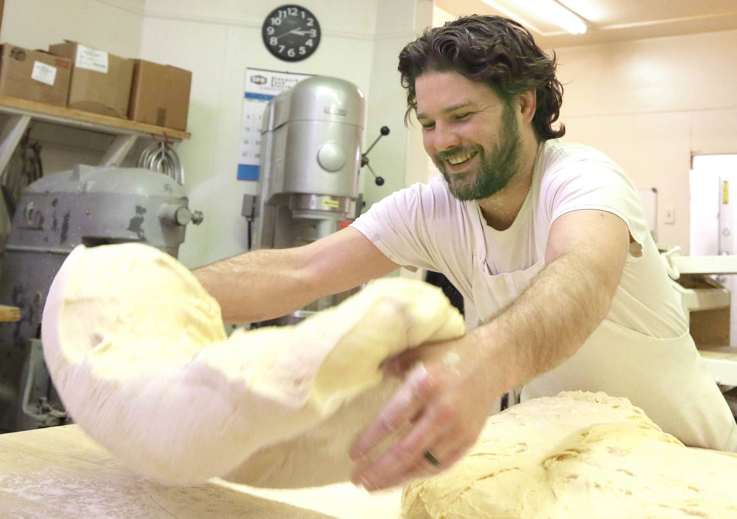 Eric Elleson, son of Ken Elleson, owner of Elleson's Bakery, separates the dough before it is sliced up for paczkis Monday, Feb. 28, 2022, in the kitchen of the bakery in Sycamore. Eric Elleson came in from Michigan especially for this day to help out his dad and members of his family who will be working all night making the paczkis from scratch to be ready at 5 a.m. tomorrow for Fat Tuesday.