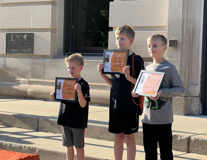 (From left) Jaxson Ruby, a first-grader from South Prairie Elementary, Samuel Schwartz, a fourth-grader from North Grove Elementary and Leo Berek, a fourth-grader from West Elementary pose after they were named finalists of the 2024 Sycamore Pumpkin Festival theme contest outside of the DeKalb County Courthouse in Sycamore on May 15, 2024.