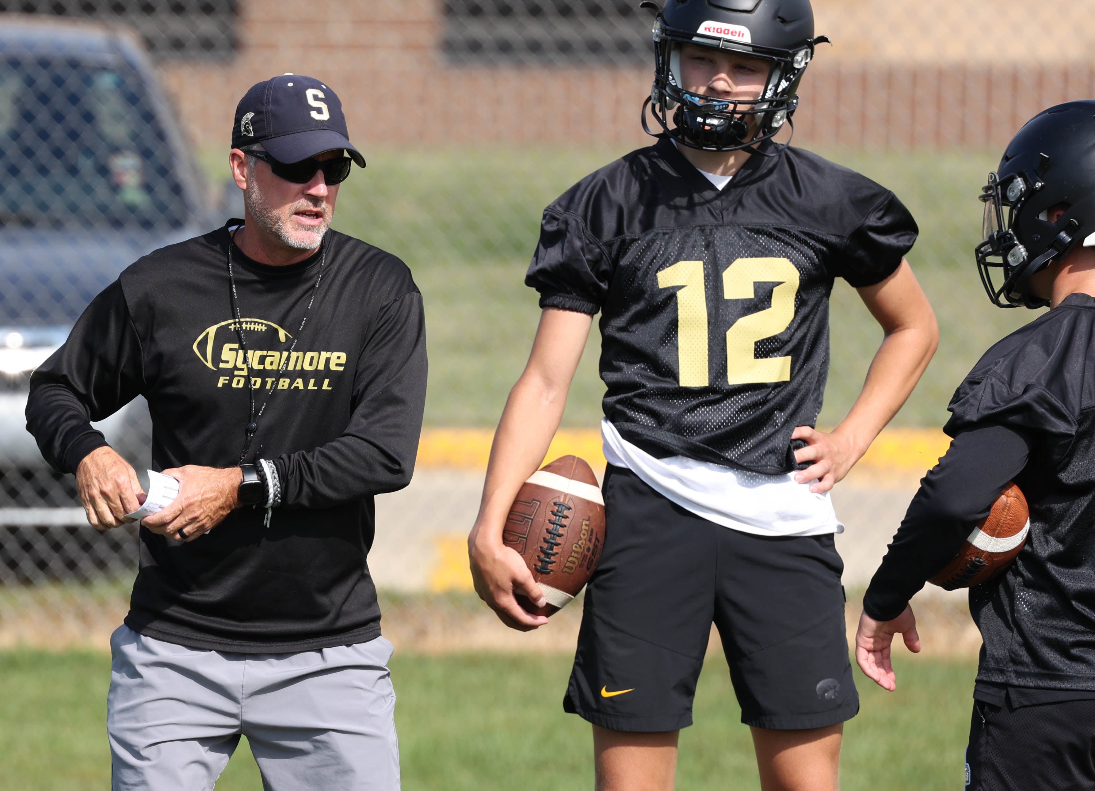 Sycamore head coach Joe Ryan talks to his quarterbacks Monday, Aug. 12, 2024, during the first practice of the regular season.