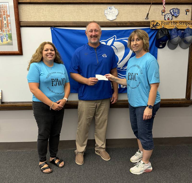 Princeton Junior Women's Club president and Princeton High School business and technology teacher, Julie Kuhne, and club co-treasurer Gail Jagers present a check to Princeton High School Principal Andy Berlinski for the 2024-2025 school year EXTRA program.