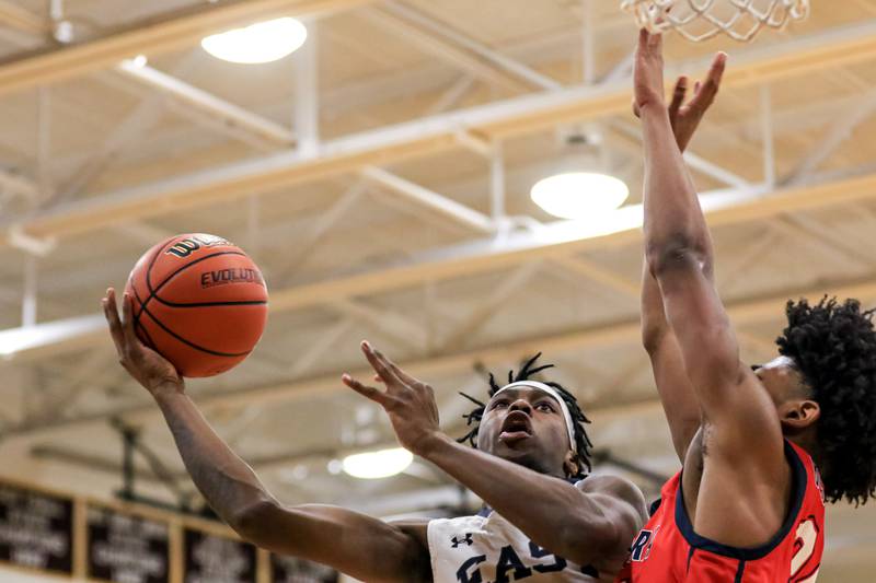 Oswego East's Mekhi Lowery (24) puts up a shot under the basket during Class 4A Lockport Regional final game between West Aurora at Oswego East.  Feb 24, 2023.