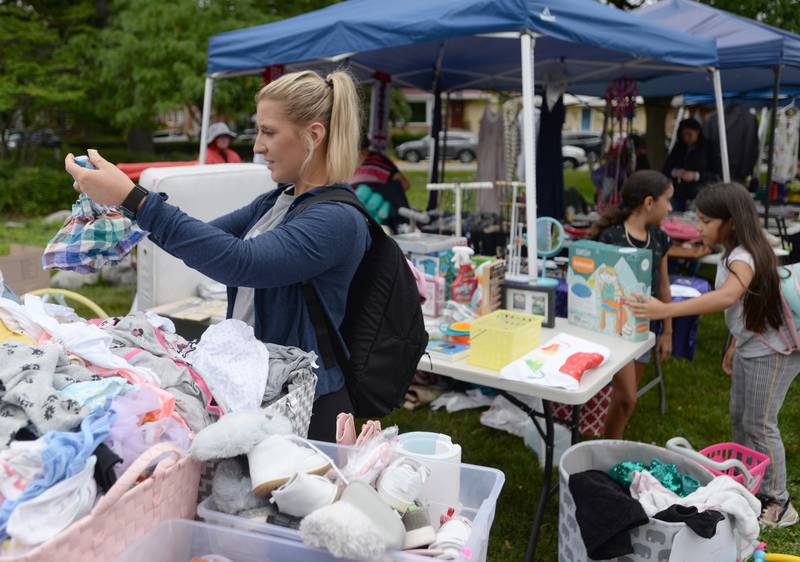 Maddie Havlik of Fox River Grove looks over some of the children clothes during the Berwyn Garage Sale Saturday July 8, 2023.