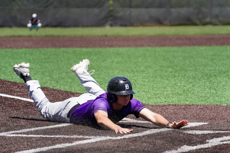 Downers Grove North's Sean Cabaj (25) slides into home for a score to take the lead in the 6th inning off of a wild pitch by Oswego East during a 4A Bolingbrook Regional Championship baseball game at Bolingbrook High School on Saturday, May 25, 2024.
