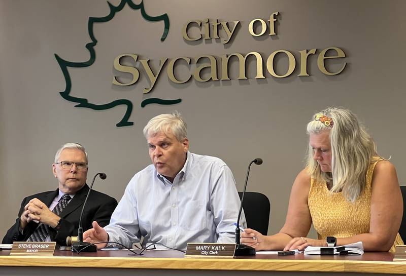 Sycamore attorney Keith Foster (left) listens, and City Clerk Mary Kalk (right) takes notes, as Sycamore Mayor Steve Braser talks during the Aug. 21, 2023 Sycamore City Council meeting.