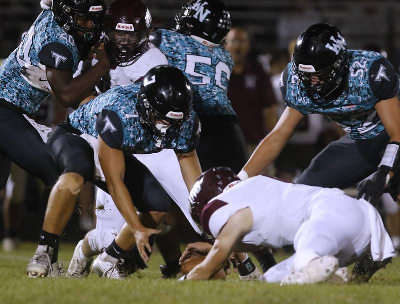 Marengo's David Lopez recovers a fumble in front of Woodstock North's Parker Halihan during a Kishwaukee River Conference football game on Friday, Sept. 13, 2024, at Woodstock North High School.