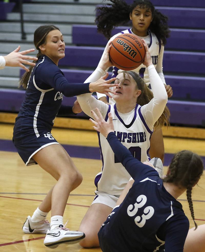 Hampshire's Chloe Van Horn tries to pass the ball as she is guarded by Cary-Grove's Morgan Haslow (left) and Cary-Grove's Ellie Mjaanes (right) during a Fox Valley Conference girls basketball game Friday, Jan. 26, 2024, at Hampshire High School.