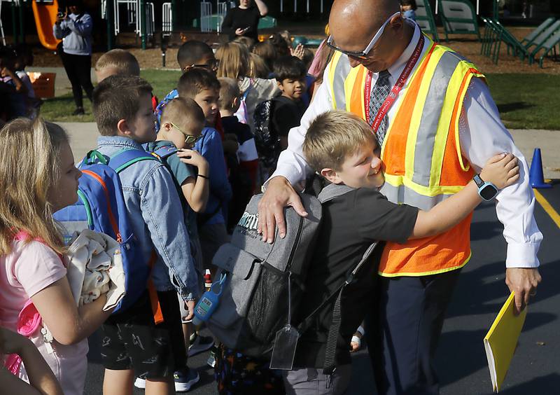 A student hugs Coventry Elementary School Principal Matthew Grubbs before for the first day of school on Wednesday, Aug. 21, 2024, at Coventry Elementary School in Crystal Lake.