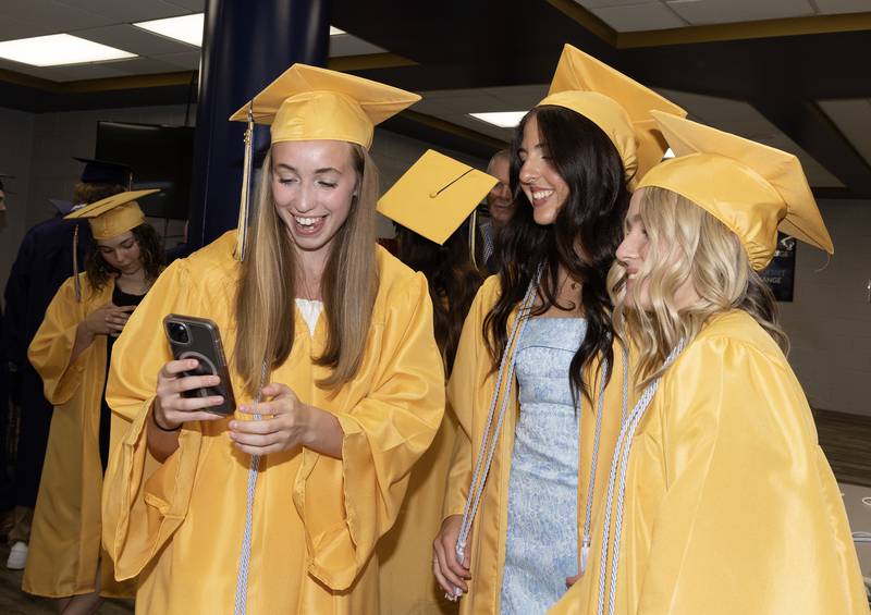 Lilly Craig, Gwen Verona and Grace Dose pose for a selfie Sunday, May 26, 2024, in the school library where students gathered for Marquette Academy High School graduation ceremony.