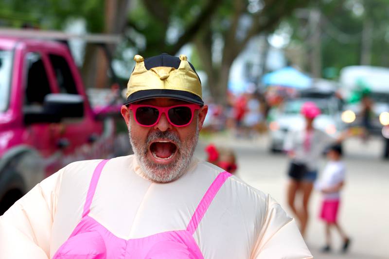 A member of the Pink Roofing team grins as part of the Fiesta Days parade along Main Street in McHenry Sunday.