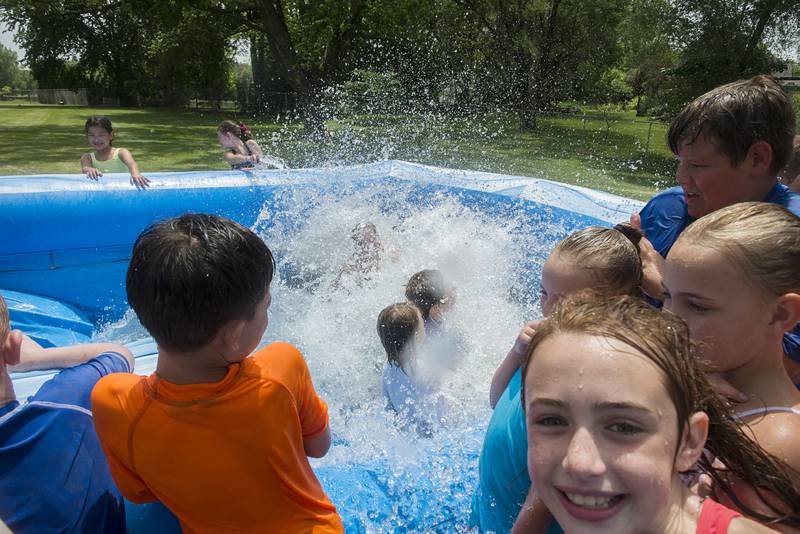 Campers get splashed Wednesday, June 15, 2022 at the end of a friends ride down the waterslide.