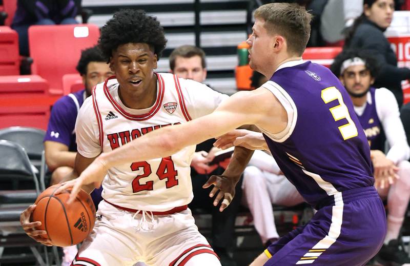 Northern Illinois Huskies guard Darweshi Hunter drives by Albany Great Danes forward Trey Hutcheson during their game Tuesday, Dec. 20, 2022, in the Convocation Center at NIU in DeKalb.